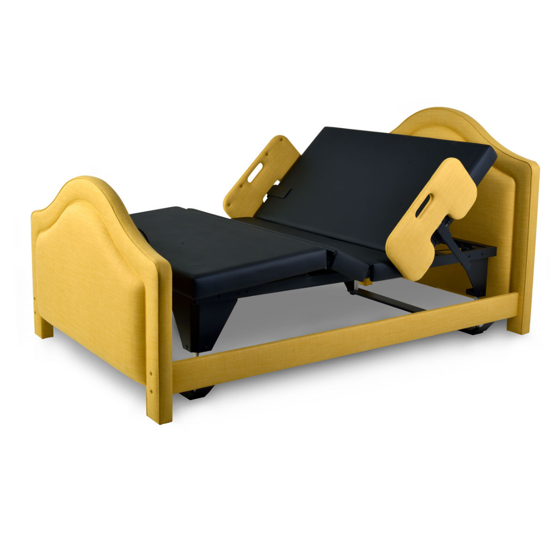The Assured Comfort® Signature Series Hi-Low Adjustable Bed features a modern light wood frame with black cushioned head, back, and leg sections, shown here in a partially raised position.